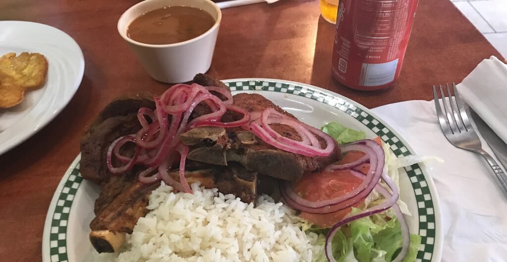Plato de la bandera dominicana con arroz blanco, carne guisada y ensalada