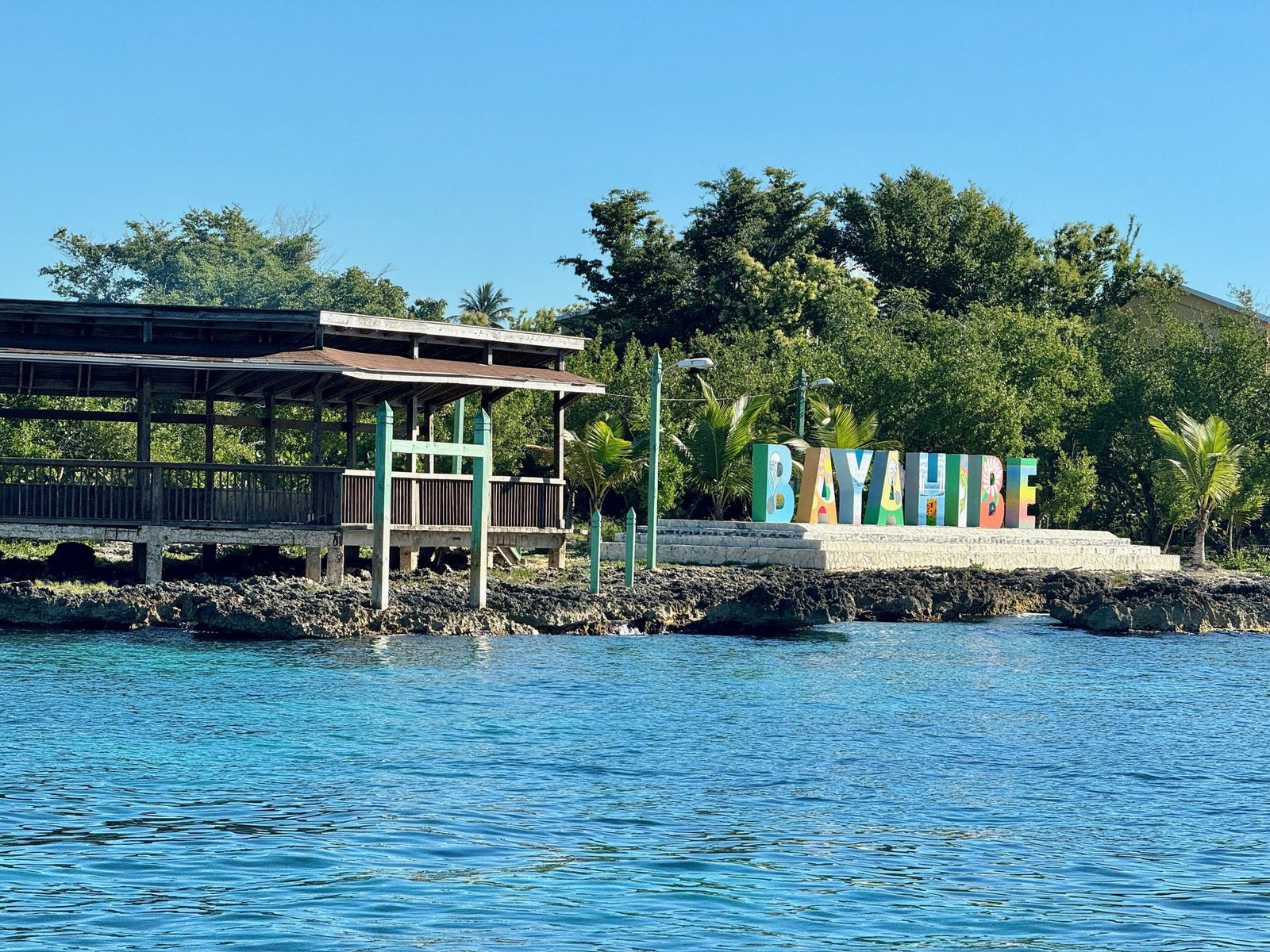 Letrero de Bayahíbe junto al muelle y el agua turquesa