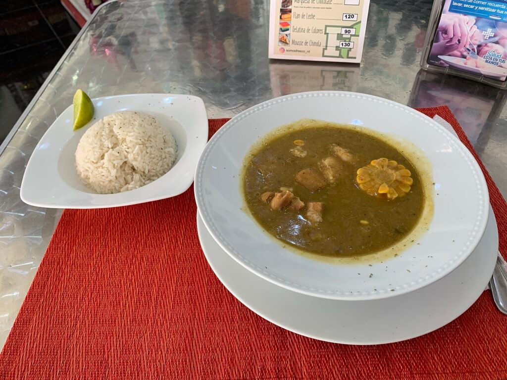 Plato de sancocho dominicano servido con arroz blanco al lado